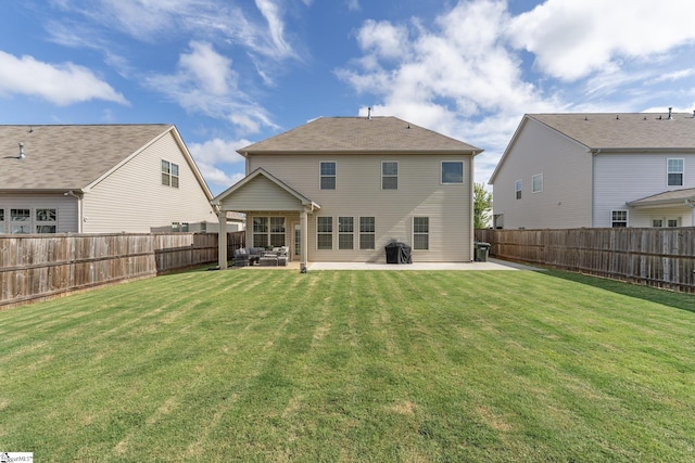 rear view of house with a lawn and a patio