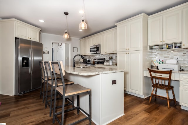 kitchen with light stone counters, sink, pendant lighting, and appliances with stainless steel finishes