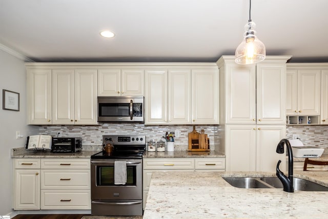 kitchen featuring sink, hanging light fixtures, appliances with stainless steel finishes, light stone countertops, and backsplash