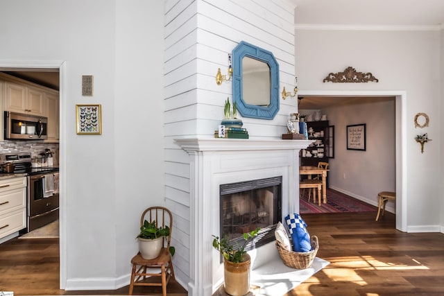 living room featuring a large fireplace, ornamental molding, and dark hardwood / wood-style floors