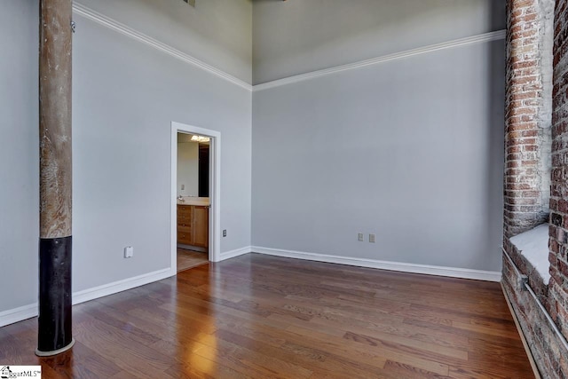 spare room with dark wood-type flooring and a high ceiling