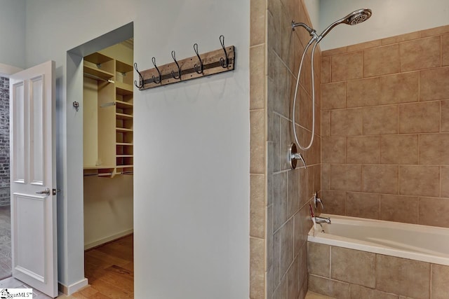 bathroom with tiled shower / bath combo and hardwood / wood-style flooring