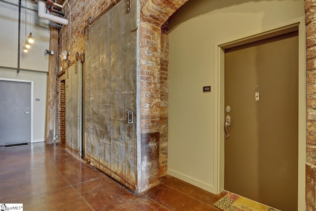 hall with brick wall and a towering ceiling