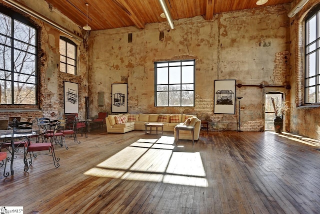 interior space with beam ceiling, wood ceiling, a wealth of natural light, and hardwood / wood-style flooring