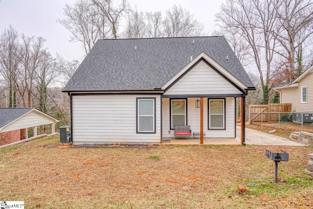 bungalow-style house with cooling unit, a carport, and a front yard