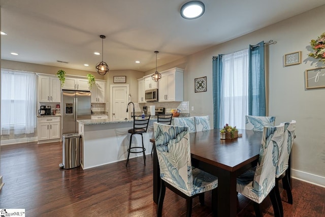 dining space featuring plenty of natural light, dark hardwood / wood-style floors, and sink