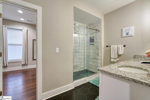 bathroom with walk in shower, vanity, and hardwood / wood-style flooring