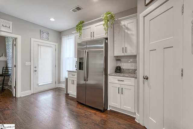 kitchen featuring white cabinetry, backsplash, dark hardwood / wood-style flooring, stainless steel refrigerator with ice dispenser, and light stone countertops