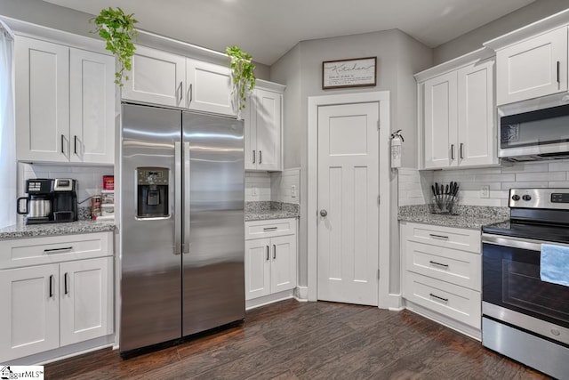 kitchen with white cabinetry, stainless steel appliances, and light stone counters