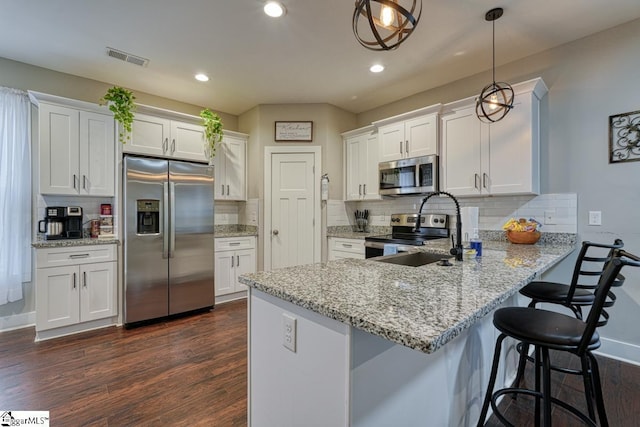 kitchen with white cabinetry, appliances with stainless steel finishes, and pendant lighting