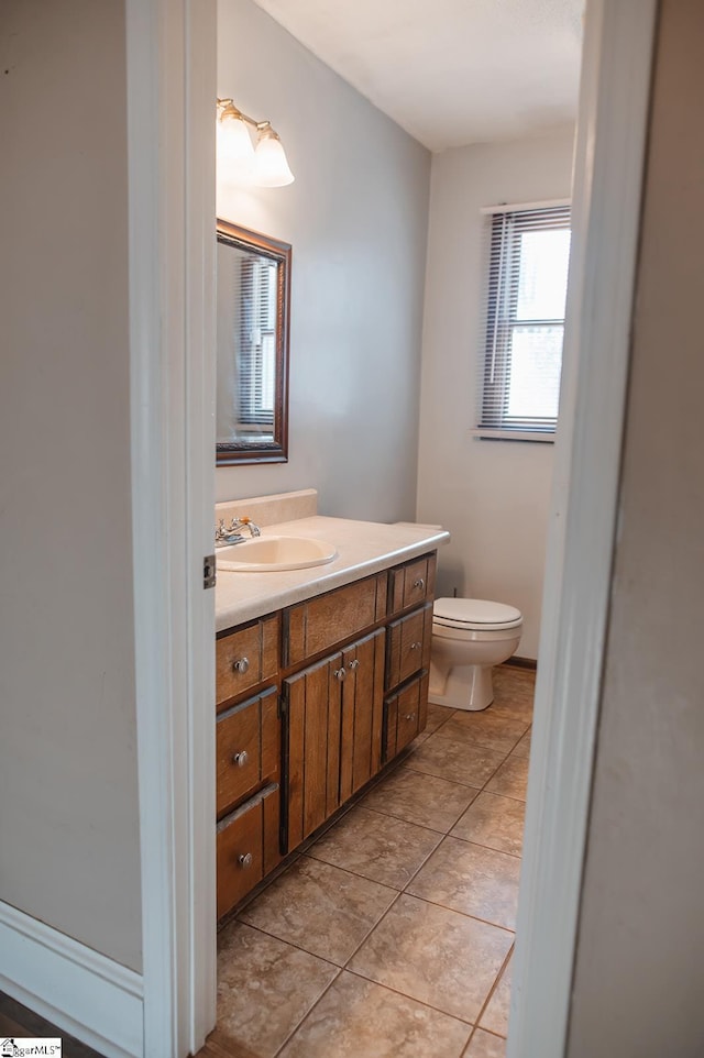 bathroom featuring vanity, tile patterned flooring, and toilet