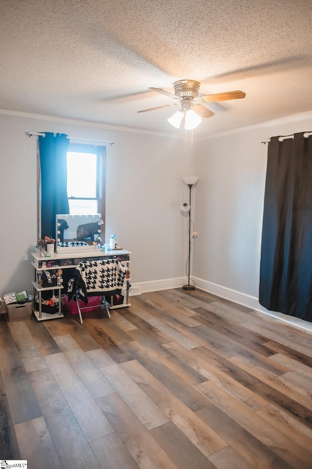 miscellaneous room featuring crown molding, wood-type flooring, and a textured ceiling