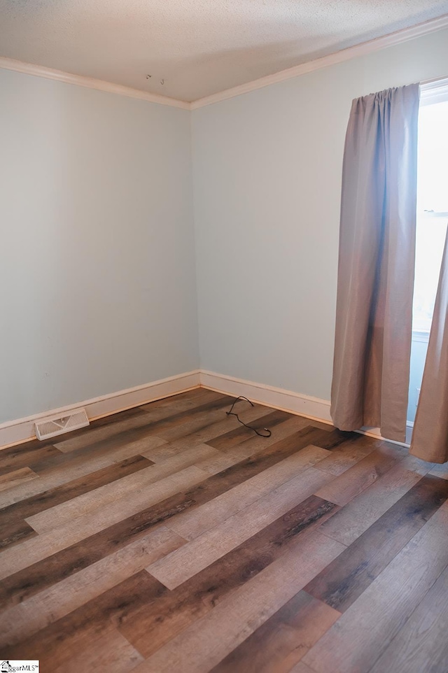 spare room with crown molding, hardwood / wood-style floors, and a textured ceiling