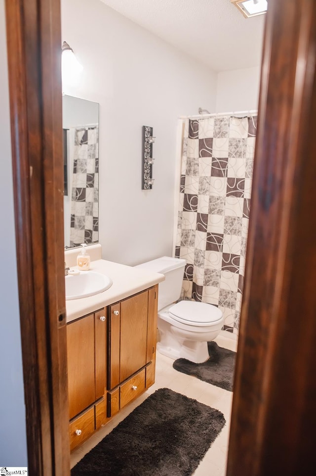 bathroom with vanity, toilet, tile patterned floors, and a shower with shower curtain