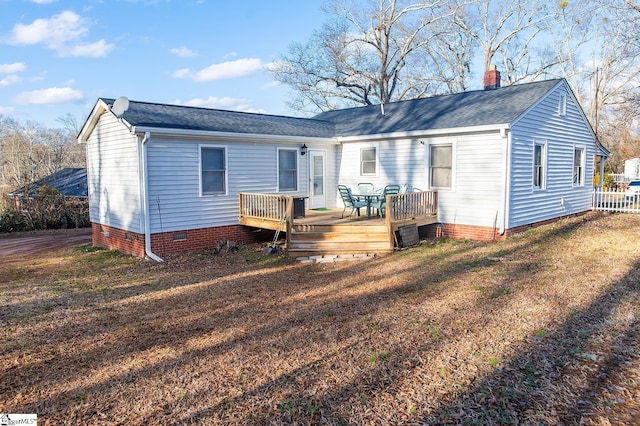 rear view of property with a wooden deck and a lawn