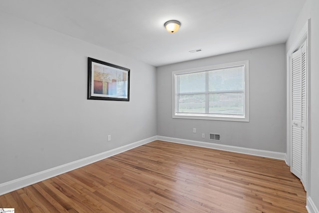 unfurnished bedroom featuring light hardwood / wood-style floors and a closet