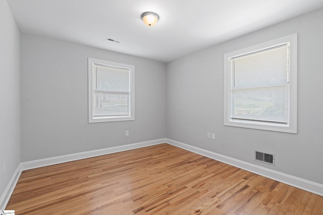 spare room with a healthy amount of sunlight and light hardwood / wood-style floors