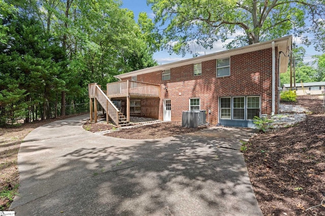 back of property with a wooden deck and central AC