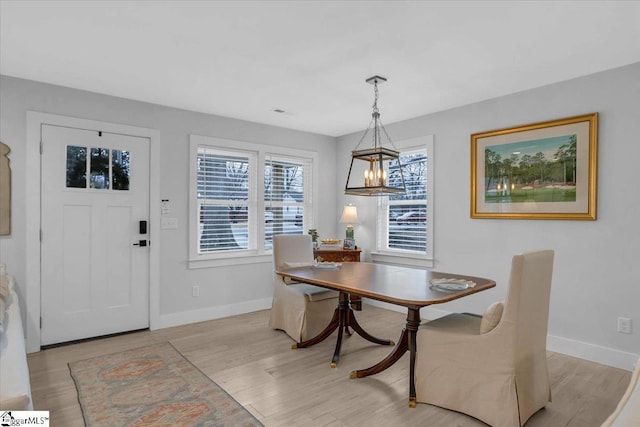 dining space featuring a notable chandelier and light hardwood / wood-style flooring