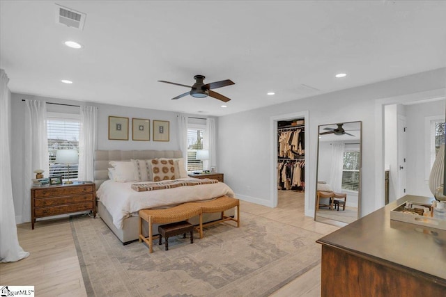 bedroom featuring multiple windows, a spacious closet, a closet, and ceiling fan