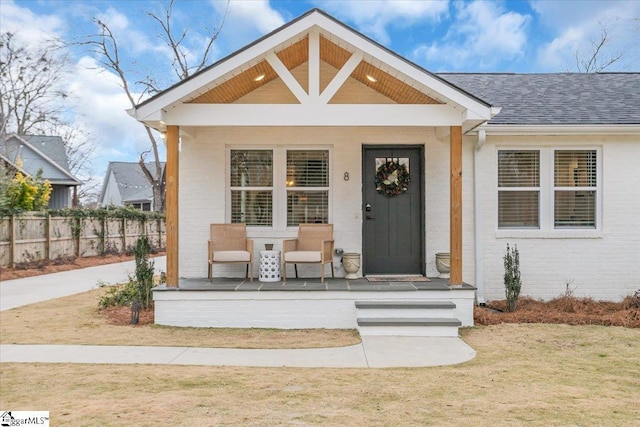 property entrance with a lawn and a porch