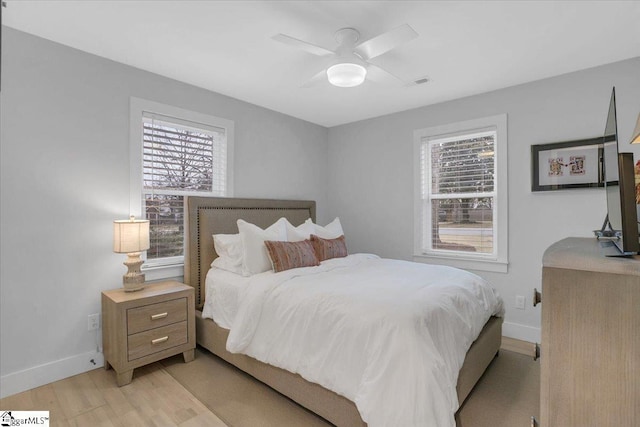 bedroom featuring multiple windows, ceiling fan, and light hardwood / wood-style floors