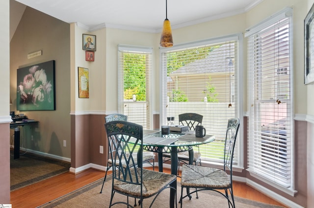 dining space featuring crown molding and hardwood / wood-style flooring