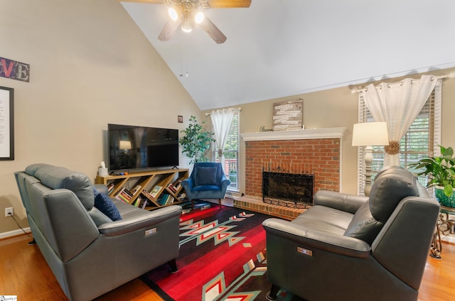 living room featuring ceiling fan, high vaulted ceiling, hardwood / wood-style floors, and a brick fireplace