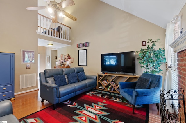 living room featuring ceiling fan, wood-type flooring, and high vaulted ceiling