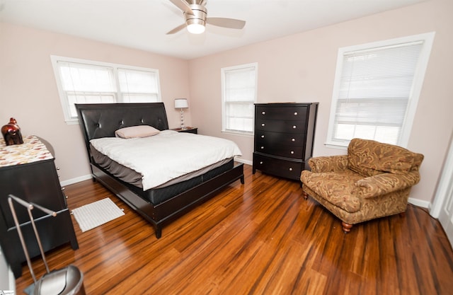 bedroom with multiple windows, ceiling fan, and dark hardwood / wood-style flooring