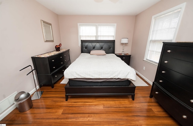 bedroom featuring dark wood-type flooring and multiple windows