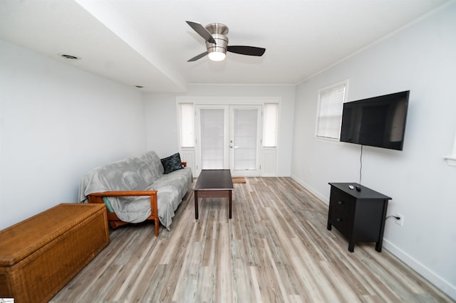 living room featuring ceiling fan, light hardwood / wood-style floors, and french doors