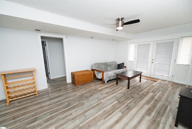 living area featuring ceiling fan, a textured ceiling, light hardwood / wood-style floors, and french doors