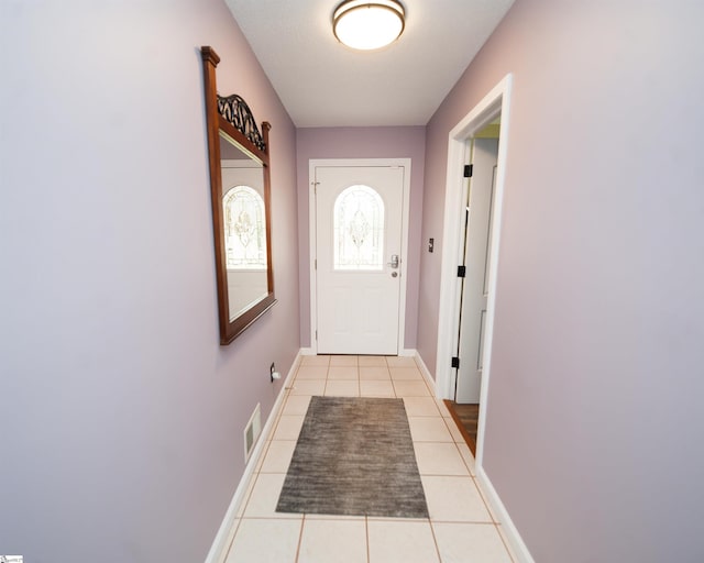 doorway to outside with light tile patterned flooring