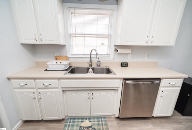 kitchen featuring white cabinetry, stainless steel dishwasher, sink, and light wood-type flooring