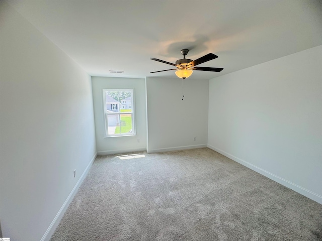 carpeted spare room featuring ceiling fan