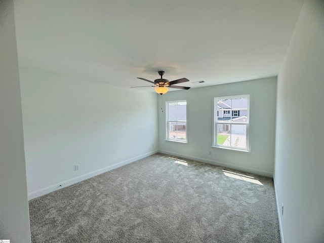 carpeted spare room with ceiling fan