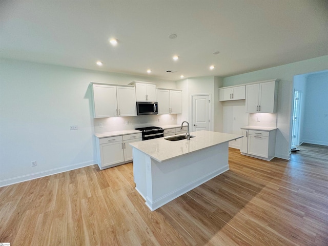 kitchen with sink, white cabinets, and black / electric stove