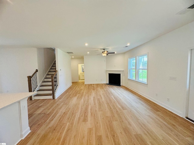 unfurnished living room featuring ceiling fan and light wood-type flooring