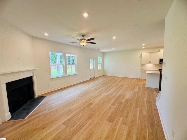 unfurnished living room with ceiling fan and light hardwood / wood-style floors