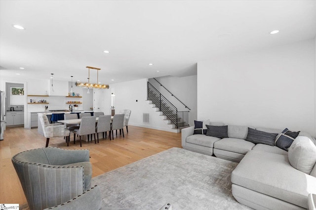 living room with a notable chandelier and light hardwood / wood-style flooring