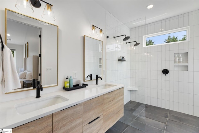 bathroom with tile patterned flooring, vanity, tile walls, and walk in shower