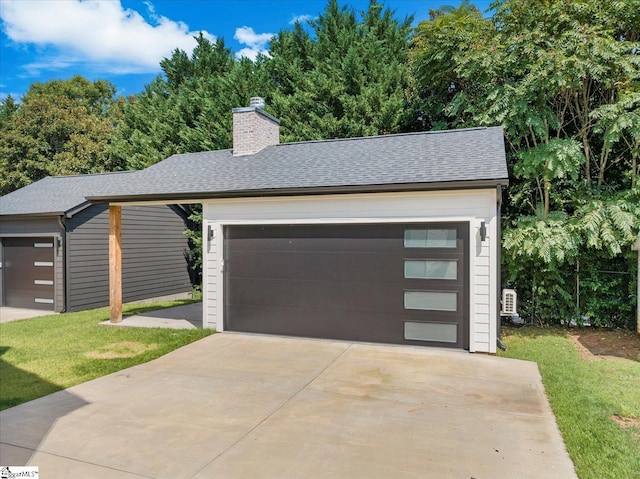 view of front of house with an outbuilding, a garage, and a front yard