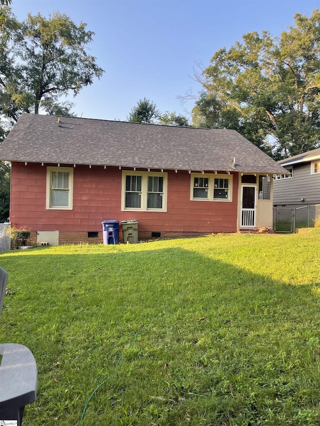 rear view of house featuring a lawn