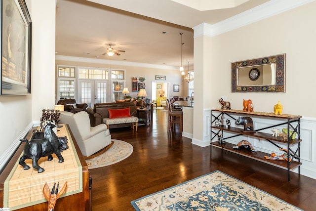 living room with french doors, ornamental molding, dark hardwood / wood-style flooring, and ceiling fan with notable chandelier