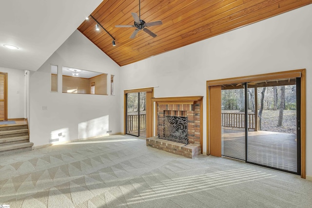 unfurnished living room with wood ceiling, carpet floors, high vaulted ceiling, and plenty of natural light