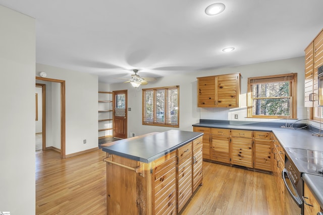 kitchen with light wood-type flooring, a kitchen island, ceiling fan, oven, and backsplash