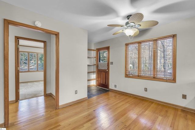 spare room with ceiling fan and light wood-type flooring