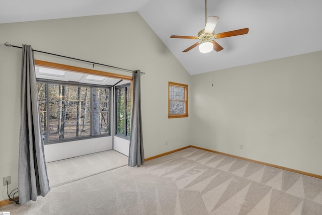 carpeted spare room with ceiling fan and high vaulted ceiling