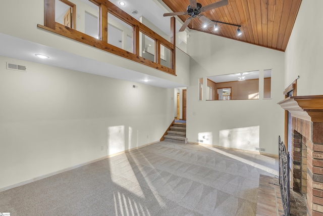 living room featuring wood ceiling, ceiling fan, high vaulted ceiling, carpet, and a fireplace